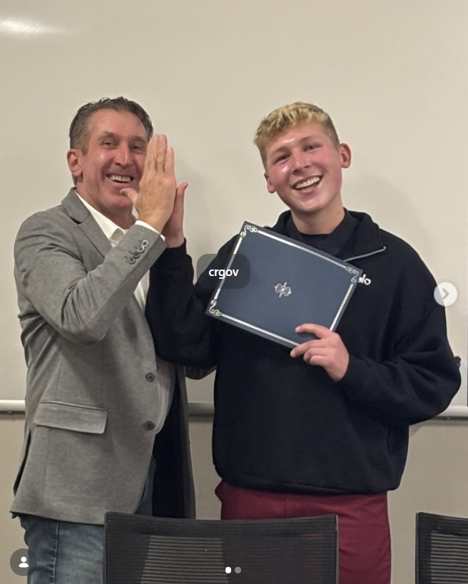 Tim Dietz giving a high five to Reilly, recognized for four years of service to the Castle Rock Teen Advisory Group